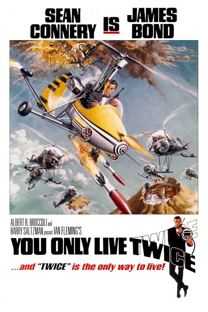 James Bond: You only live twice Filmposter van You only live twice: witte achtergrond met een tekening in een kader van James Bond in een minihelicopter vliegend boven een zee met een vulkaaneiland; hij wordt achtervolgd door enkele helikopters.